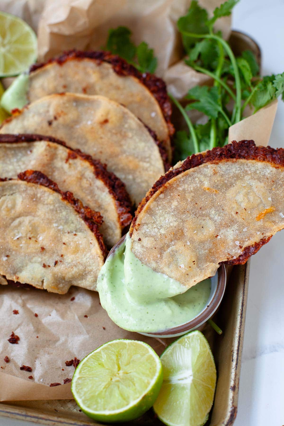 black bean taco dipped into avocado lime crema